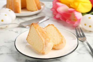 Lezzetli kek parçaları, Paskalya yumurtaları ve laleler açık mermer masada, yakın plan.