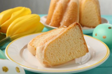 Lezzetli kek parçaları, Paskalya yumurtaları ve laleler masada, yakın plan.