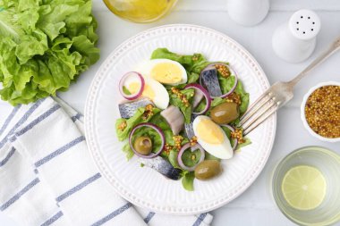 Ringa balıklı lezzetli salata, yumurta, hardal ve sebzeler beyaz fayanslı masada servis edilir.