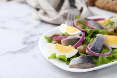 Ringa balıklı lezzetli salata, yumurta ve sebzeler beyaz mermer masada, yakın plan. Metin için boşluk