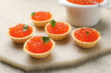 Kırmızı havyarlı tart ve bej masadaki maydanoz, yakın plan.