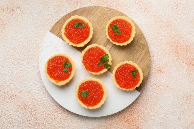 Kırmızı havyarlı turta ve bej arka planda maydanoz.