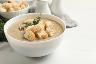 Ekmek arası kremalı leziz mantar çorbası ve dereotu beyaz masada servis edilir.