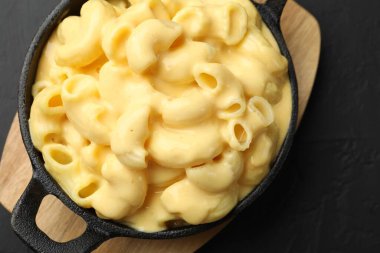 Siyah masanın üstünde nefis peynirli makarna.