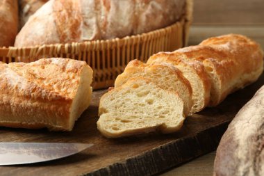 Tahta masadaki farklı taze ekmek türleri, yakın çekim.