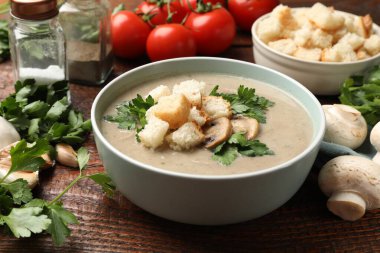 Ekmek arası mantar kremalı çorba, maydanoz ve ahşap masa malzemeleri, yakın plan.