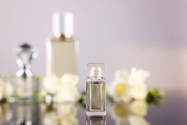 Ayna yüzeyinde aromatik parfüm şişesi bulanık arka planda, yakın plan