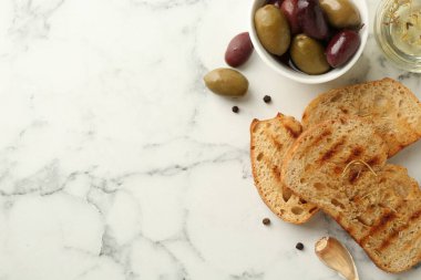 Beyaz mermer masada yağlı, zeytinli ve baharatlı tost ekmeği düz yerde. Metin için boşluk