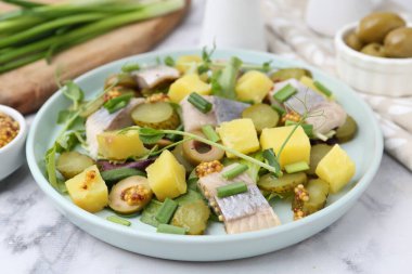 Ringa balıklı lezzetli salata ve beyaz mermer masada malzemeler, yakın plan.