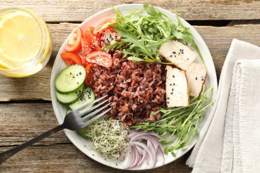 Kahverengi pirinçli nefis salata ve ahşap masada içki, düz yatıyordu.