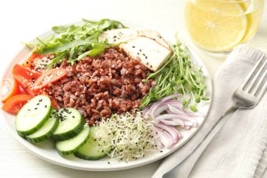 Beyaz ahşap masada kahverengi pirinçli leziz salata, yakın plan.