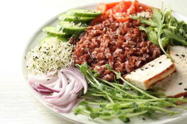 Beyaz ahşap masada kahverengi pirinçli leziz salata, yakın plan.