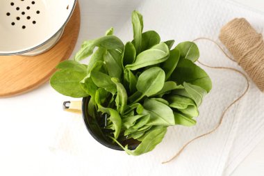 Taze kuş yaprakları kasede, sicimde ve kevgire bembeyaz masada, düz yatıyordu.