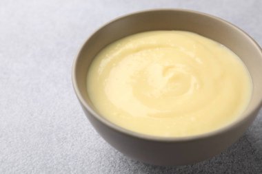 Açık gri masada kasede vanilyalı puding, yakın plan. Metin için boşluk
