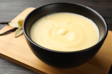 Tahta masadaki kasede lezzetli vanilyalı puding, yakın plan.