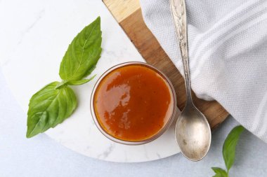 Cam kasede lezzetli köri sosu ve beyaz masada fesleğen.