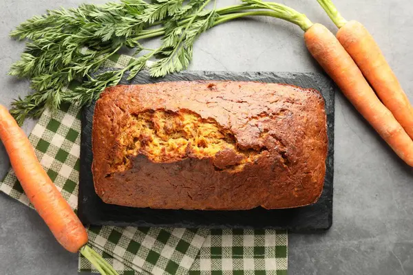 Lezzetli havuçlu kek ve sebzeler gri desenli masada, düz yatıyordu.