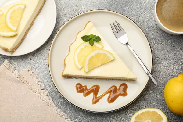 Lezzetli limonlu cheesecake parçaları gri desenli masada servis ediliyor.