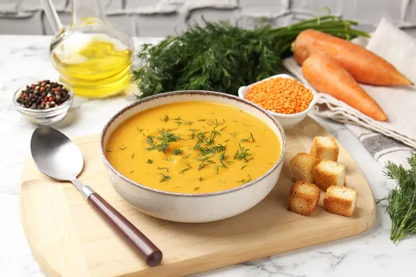 Lezzetli mercimek kremalı çorba ve beyaz mermer masa malzemeleri.