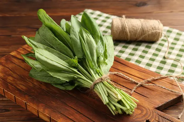 Bir demet taze yeşil kuş yaprağı ve ahşap masa üzerinde sicim, yakın plan