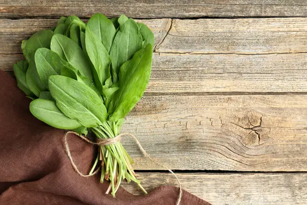 Ahşap masanın üstünde taze yeşil kuş yaprakları var. Metin için boşluk