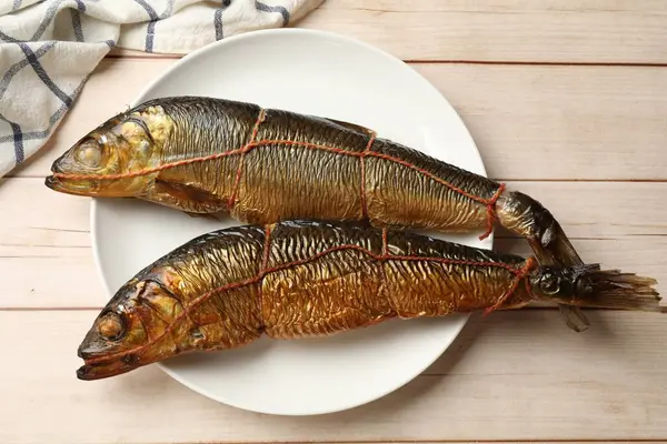 Beyaz ahşap masada nefis tütsülenmiş ringa balıkları.