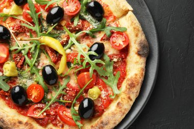 Domatesli, zeytinli, biberli ve roka soslu lezzetli pizza.