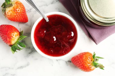 Delicious strawberry sauce and fresh berries on white marble table, flat lay