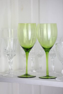 Beyaz rafta farklı boş bardaklar