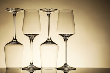 Ayna yüzeyinde bej arkaplana karşı birçok boş temiz bardak