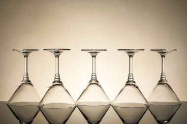 Ayna yüzeyinde bej arkaplana karşı birçok boş temiz bardak