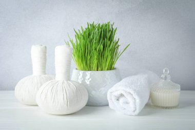 Açık gri arkaplana karşı beyaz masa üzerinde buğday çimi ile spa bileşimi