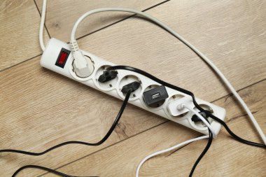 Eklenti güç panosu ahşap zemindeki prizlerle aşırı yüklenmiş, üst görünüm