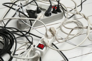 Uzatma güç panoları ahşap zemindeki tıkaçlarla aşırı yüklenmiş, yakın plan.