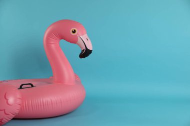 Açık mavi arkaplanda şişirilebilir flamingo şekilli halka, metin için boşluk