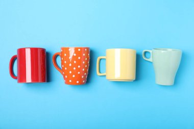 Açık mavi arkaplanda bir sürü renkli fincan, düz yatıyordu.