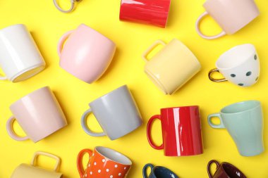 Sarı arkaplanda bir sürü renkli fincanlar var.