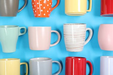 Açık mavi arkaplanda bir sürü renkli fincan, düz yatıyordu.