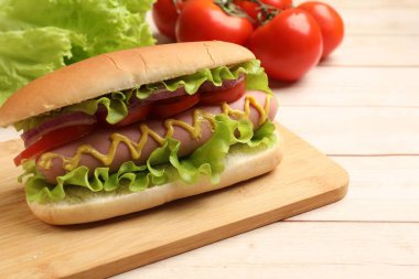 Domatesli, soğanlı, marullu ve hardallı lezzetli sosisli sandviç.