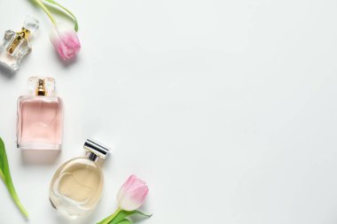 Kokulu parfüm şişeleri ve beyaz arka planda güzel çiçekler. Metin için boşluk