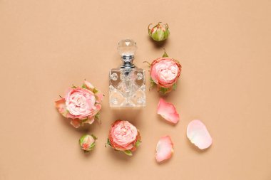 Düz kompozisyon, aromatik parfüm şişesi ve bej arka planda güzel çiçekler.