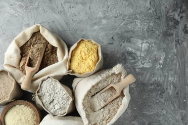 Gri desenli masa ve düz yatak üzerinde farklı tipte un torbaları. Metin için boşluk