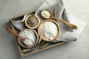 Açık gri masa üzerinde farklı un türleri, üst görünüm