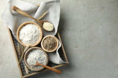 Açık gri masadaki farklı un türleri, üst görünüm. Metin için boşluk