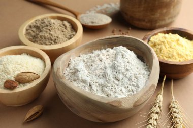 Açık kahverengi masada farklı tipte un, yakın plan.