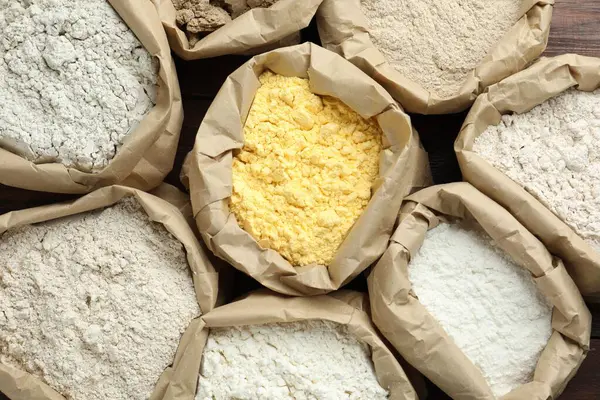 Tahta masadaki kağıt torbalarda farklı türde un var.