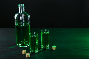 Absinthe shot bardakları, şişe ve esmer şeker masada, mesaj için yer var.