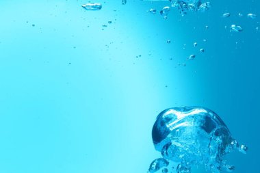 Açık mavi arka planda birçok su kabarcığı, yakın plan. Metin için boşluk