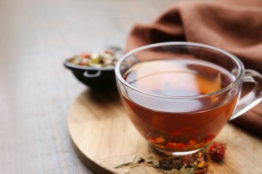 Lezzetli bitkisel çay ve kuru yapraklar ahşap masada, yakın plan. Metin için boşluk