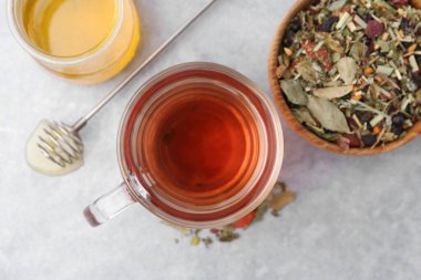 Gri masa üzerinde bal ve kuru yapraklı lezzetli bitkisel çay.